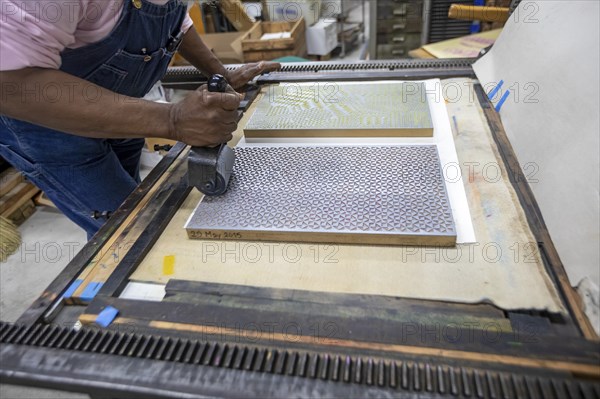 Detroit, Michigan, Amos Kennedy works in his letterpress printing shop. Kennedy prints posters and