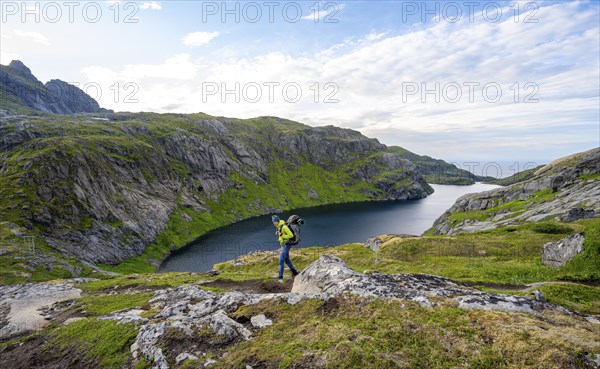 Climbers on a hiking trail, mountain landscape with lake Fjerddalsvatnet, Moskenesoya, Lofoten,