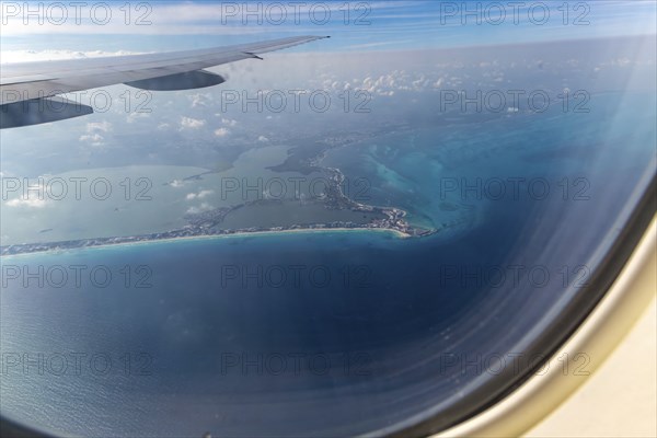 Aerial view through plane window of Caribbean coastline buildings in the hotel zone, Cancun,