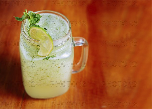 Refreshing lemonade with mint on wooden table. Lemonade drink on wooden table