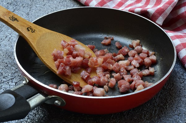 Fried bacon cubes in pan, bacon