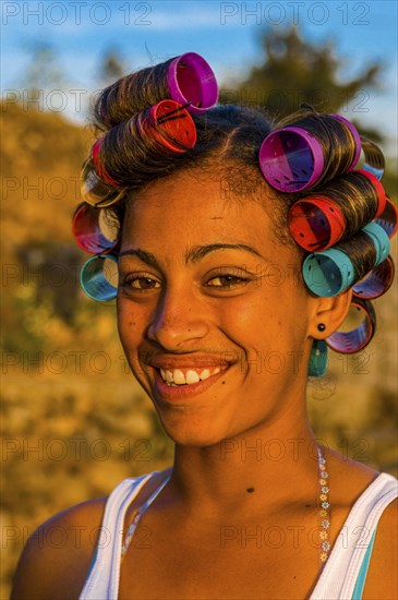 Local woman with curling irons is laughing. Fogo. Cabo Verde. Africa