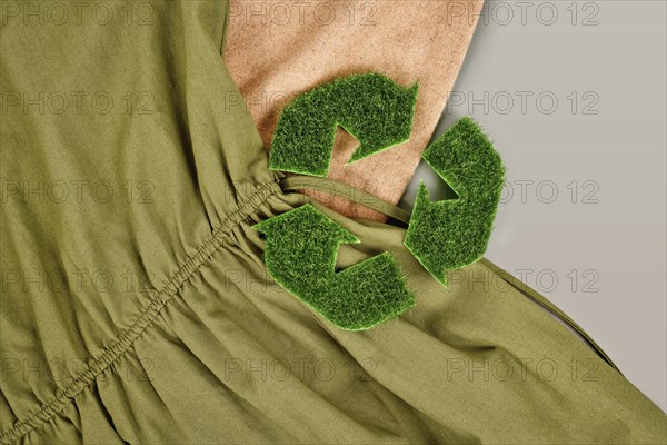 Environmental friendly produced clothing with recycling arrow symbol made out of grass