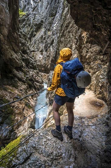Hiker in a gorge, Hammersbach flows through Höllentalklamm, near Garmisch-Partenkirchen,