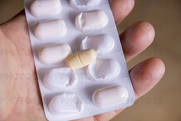 Hand holding a blister pack with a tablet