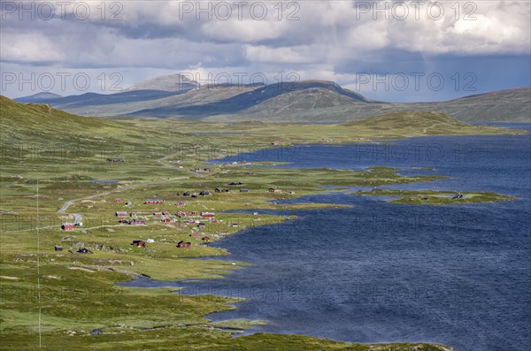 Road and red houses by a large lake, Fjell, barren mountain landscape, Oystre Slidre, Jotunheimen