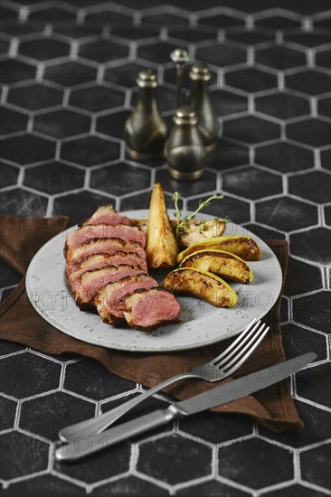 Sliced duck breast cooked to a perfect medium-rare served with caramelised apples and pears on a