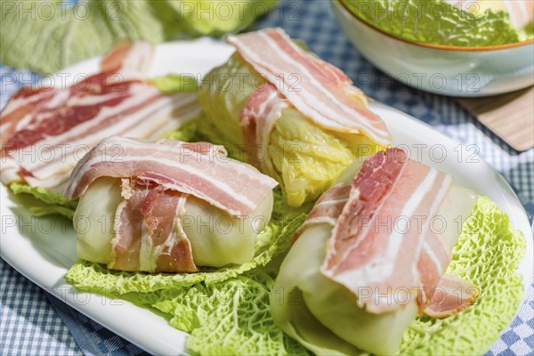 Preparation of savoy cabbage roulades with bacon on cabbage leaves