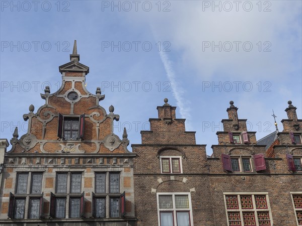 Historic brick buildings with ornate gables and red shutters against a blue sky, nijmegen, the