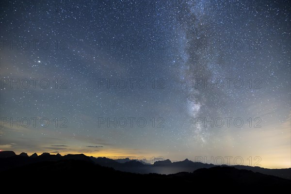 Clear starry sky with visible Milky Way and mountains in the background, Hochalp, Urnäsch,