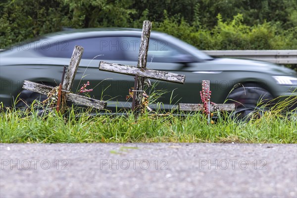 Cross on a country road, symbol of remembrance for three road accident victims. Laichigen,