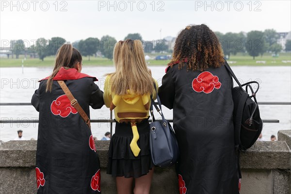 Three costumed woman looking at the Rhine, back view, cosplay at Japan Day Düsseldorf, North