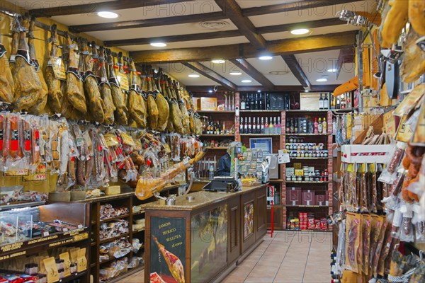 A rustic shop filled with hanging hams and other foods on the shelves, Plasencia, Cáceres, Caceres,