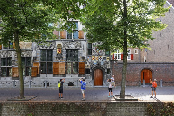Historic city centre of Delft, tourists photograph Gemeenlandshuis van Delfland, town hall, oldest