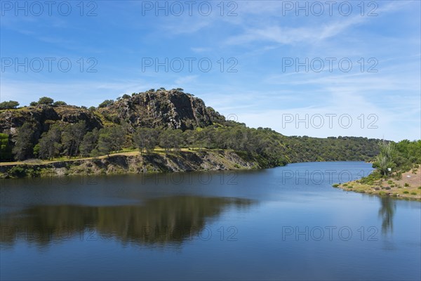 River with large rock in the background and blue sky, landscape characterised by natural wonders,