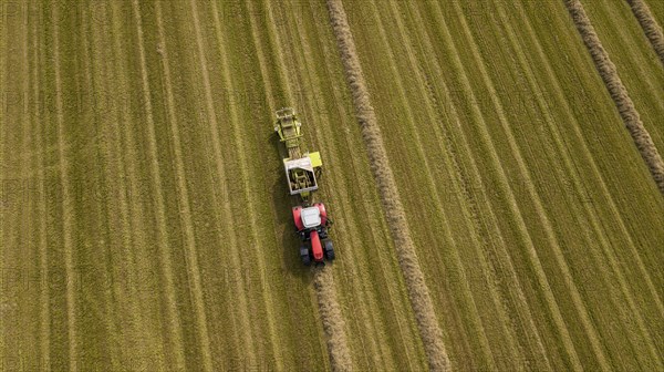 A tractor with a straw baler in a field