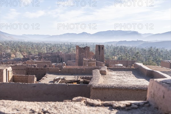 View of a village and an oasis of date palms from the rooftop of an ancient kasbha in Morocco