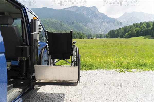 Photo of black electric lift specialized vehicle for people with disabilities. Empty wheelchair on