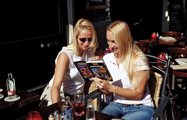 Two tourists reading a travel guide, Netherlands, Holland, Amsterdam