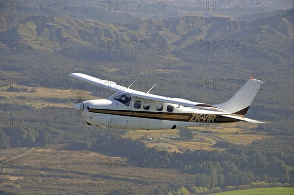 Single engined light aircraft flying over Westland, New Zealand, Oceania