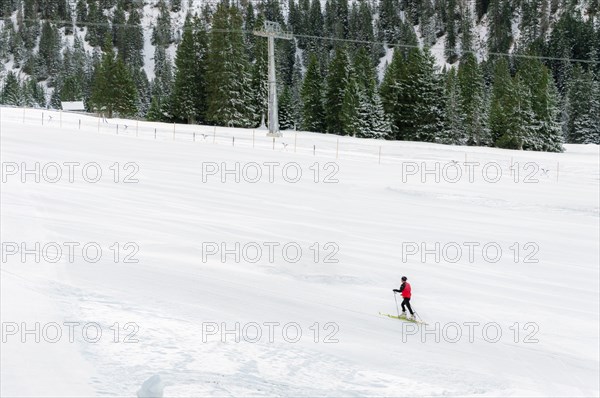 Minimal style winter landscape with ski slope full of snow, surrounded by snowy fir trees, and a