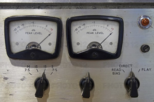 A close up of two old decibel meters on an old vintage reel to reel tape recorder with control