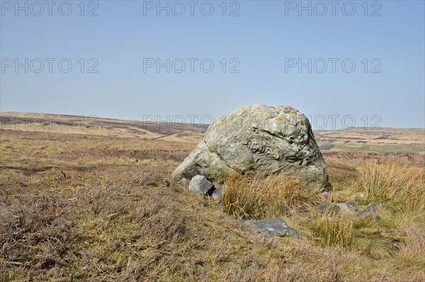Pennine landscape with large old boulder or standing stone on midgley moor in west yorkshire