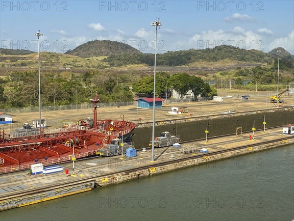 Ship in a lock in a canal, surrounded by industrial buildings, panama city, panamakanl, panama,