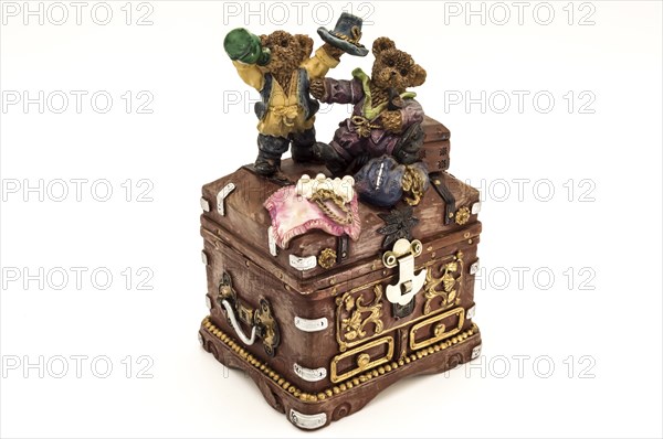 Old treasure chest topped by two little bears on a white background