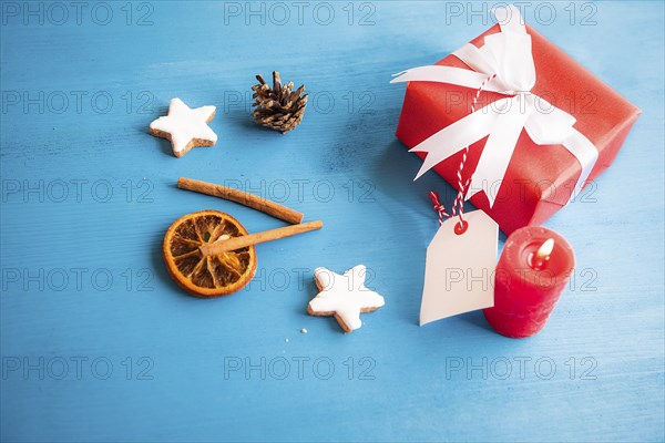 Gift, wrapped in red paper and tied with white ribbon and bow, with a blank tag attached to it,