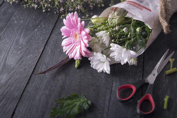 Above view image about the activity of flower packaging, with a bouquet of chrysanthemum flowers
