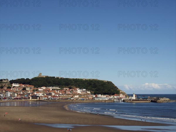 View of scarborough south bay with beach and town on a sunlit summer day with the harbour and