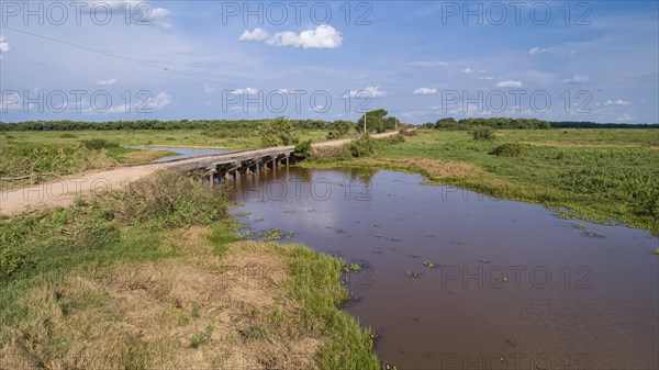 Aerial view of Transpantaneira wooden bridge crossing a river, sunny sky, Pantanal Wetlands, Mato