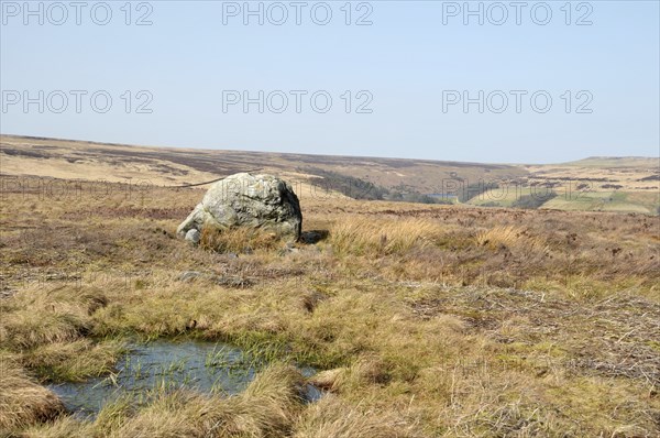 Pennine landscape with large old boulder or standing stone on midgley moor in west yorkshire