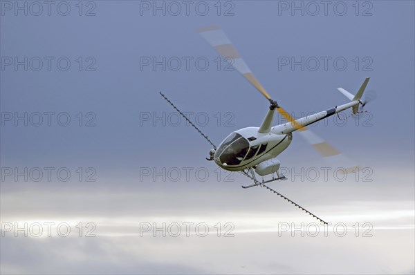 Helicopter spraying fertiliser on a crop in Westland, New Zealand, Oceania