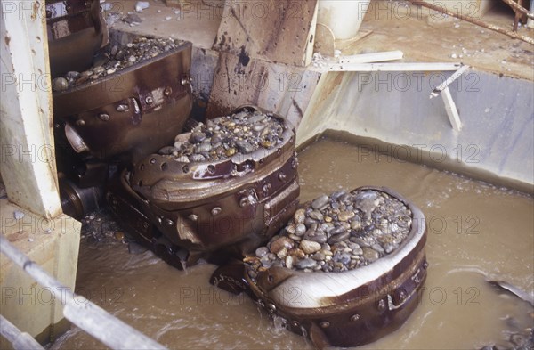 Bucket chain carries river bed gravel into the Ngahere Gold Dredge, West Coast, South Island, New