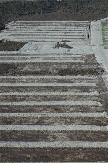 Digger excavating land to make humps and hollows for farmland, West Coast, South Island, New