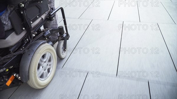 Man on electric wheelchair using a ramp. Accessibility concept