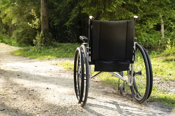 Photo of empty wheelchair parked in park, health care concept