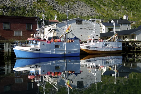 Fishing boats reflected in the Gryllefjord, Senja, Troms, Norway, Europe