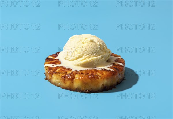 Summer dessert, roasted pineapple ring dipped in rum sauce, with a scoop of vanilla ice cream.