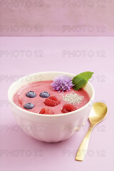 Raspberry smoothie bowl with blueberries, white chia seeds and raspberries in a bowl