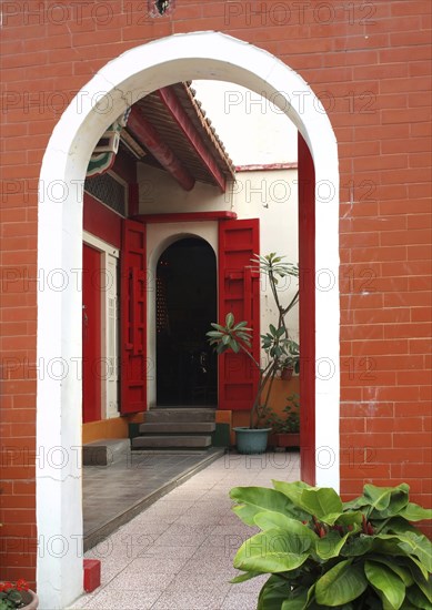 A Chinese temple with a courtyard and red doors