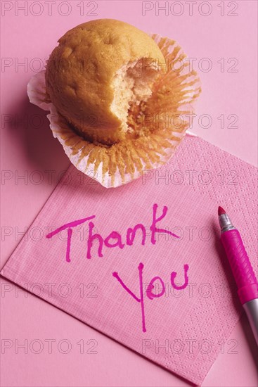 Bitten muffin on a pink napkin. Paper napkin with