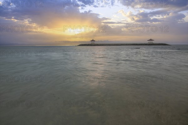 Beautiful seascape in the morning. Tropical sandy beach with breakwater and reflection of the sky