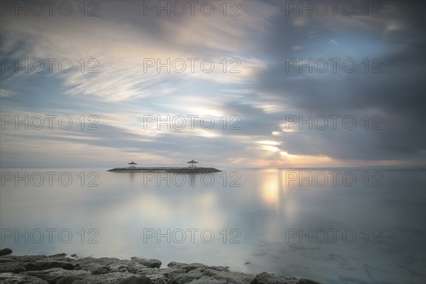 Beautiful seascape in the morning. Tropical sandy beach with breakwater and reflection of the sky