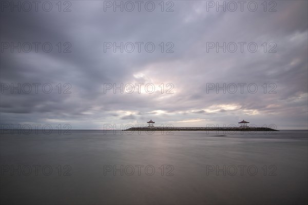 Beautiful seascape in the morning. Tropical sandy beach with breakwater and reflection of the sky