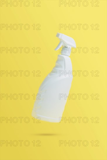 Levitation, flying blank toilet or window cleaner bottle with sprayer. Isolated on yellow