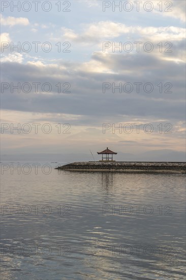 Beautiful seascape in the morning. Tropical sandy beach with breakwater and reflection of the sky