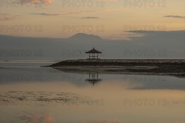 Beautiful seascape in the morning. Tropical sandy beach with breakwater and reflection of the sky